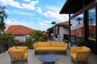 a patio with a couch and chairs on a balcony at Resort QSB - Um novo padrão de conforto e lazer no coração da cidade in Pirenópolis