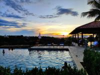 a swimming pool with a sunset in the background at Resort QSB - Um novo padrão de conforto e lazer no coração da cidade in Pirenópolis