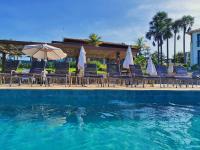 a swimming pool with chairs and umbrellas and the water at Resort QSB - Um novo padrão de conforto e lazer no coração da cidade in Pirenópolis