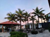 a resort with palm trees and chairs and tables at Resort QSB - Um novo padrão de conforto e lazer no coração da cidade in Pirenópolis