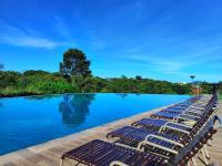 a row of lounge chairs next to a swimming pool at Resort QSB - Um novo padrão de conforto e lazer no coração da cidade in Pirenópolis
