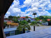 a view of a town with palm trees and buildings at Resort QSB - Um novo padrão de conforto e lazer no coração da cidade in Pirenópolis
