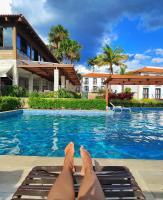 a person laying on a mat in a swimming pool at Resort QSB - Um novo padrão de conforto e lazer no coração da cidade in Pirenópolis