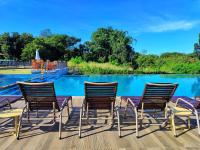 a group of chairs sitting on a deck by a pool at Resort QSB - Um novo padrão de conforto e lazer no coração da cidade in Pirenópolis