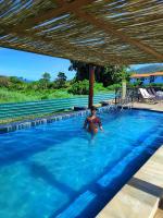 a woman is standing in a swimming pool at Resort QSB - Um novo padrão de conforto e lazer no coração da cidade in Pirenópolis
