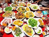 un tavolo con molti piatti di cibo sopra di Nhà Hàng Khách Sạn Trà Cổ a Trà Cổ