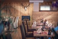 Un restaurante con mesas y sillas y una chimenea. en Hotel Alte Mühle 4 Stelle, en Campo Tures