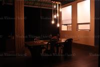 un comedor con mesa y sillas por la noche en Woodlands Wilderness Chalet, en Mādāri Hāt