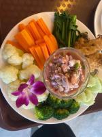 a plate of food with vegetables and a bowl of dip at Ban Nokngang campsite in Ban Nok Ngang