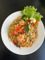 a plate of noodles with shrimp and vegetables on a table at Ban Nokngang campsite in Ban Nok Ngang