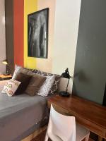 a bedroom with a bed with a desk and a painting at Lower Price, More Style, Discount Studio In San Juan,Pr, Beach, Free Bikes in San Juan