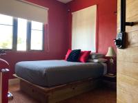 a bedroom with a bed with red walls and windows at Lower Price, More Style, Discount Studio In San Juan,Pr, Beach, Free Bikes in San Juan