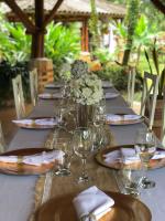 Yopo Resort في Pedregal: طاولة طويلة مع كؤوس النبيذ و إناء من الزهور