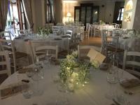 uma sala de jantar com mesas brancas e cadeiras com flores em Relais Borgofasceo em Ortovero