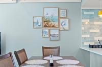 ein Esszimmer mit einem Tisch und sechs Bildern an der Wand in der Unterkunft Ocean&#39;s Bliss at Arcadian Dunes in Myrtle Beach