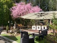 una mesa, sillas y una sombrilla en el jardín en Kakureyado Fujikawaguchiko, en Fujikawaguchiko