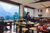 een vrouw in een restaurant met tafels en stoelen bij voco Guilin Yangshuo in Yangshuo