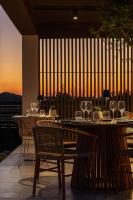 una mesa y sillas con copas de vino en el balcón en The Ritual, A Wellness Retreat, en Lampi