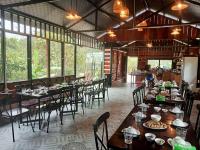 Un comedor con mesas y sillas y ventanas. en Draha In Halong - Refined Retreat - The Aussie Choice, en Ha Long