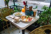 uma mesa de pequeno-almoço com ovos e torradas e um copo de sumo de laranja em La Bonita - Phu My Hung em Cidade de Ho Chi Minh