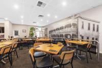 un restaurante con mesas y sillas de madera y un mural en The Commercial Hotel, en Mount Gambier