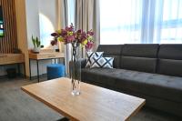 Un jarrón de flores sobre una mesa en una sala de estar. en Hotel Centrum Malbork, en Malbork