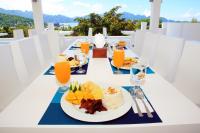 Una mesa con un plato de comida y vasos de jugo de naranja. en Coron Bluewave Hotel, en Corón