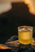 a glass of beer sitting on a table at Honeymoon Petra Villas in Imerovigli