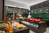 a chef is standing in a kitchen with food at Yinmo Hotel in Shahe