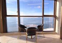 Una mesa y sillas en una habitación con una ventana grande. en WAVEM HOTEL East, en Siheung