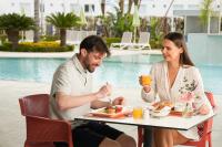 a man and a woman sitting at a table eating food at Faros Hotel Ayia Napa in Ayia Napa