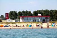 un gruppo di persone su una spiaggia vicino all'acqua di Campingplatz Sütel a Ölendorf