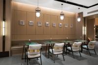 a waiting room with tables and chairs and pictures on the wall at Yinmo Hotel in Shahe