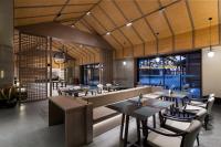 a restaurant with tables and chairs and a large window at Yinmo Hotel in Shahe