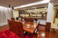 una sala da pranzo con tavolo in legno e una cucina di Asante Karibu House ad Arusha