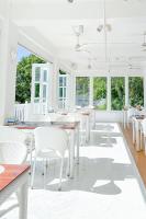 Un comedor con mesas blancas y sillas blancas. en The Mark Resort Cebu, en Lapu Lapu City