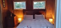 1 Schlafzimmer mit einem Bett und 2 Fenstern in der Unterkunft Rameka Chalet in Takaka