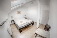 Un dormitorio blanco con una cama y una silla. en Cuba Bar &amp; Hostel, en České Budějovice