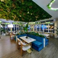 een restaurant met een blauwe bank en tafels en stoelen bij Harmony Grand Resort Private Apartment 11-2 in Sunny Beach