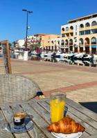 een tafel met een glas sinaasappelsap en een croissant bij La Perle Marine, Cosy et rénové, 200 m de la plage, 1 chambre, parking et Wifi in Sète