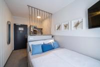a bedroom with a bed with two blue pillows at WIROtel Warnemünde in Warnemünde