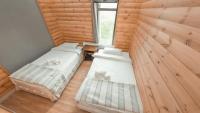 two beds in a room with wooden walls at Big Sky Lodge at Terelj in Ulaanbaatar