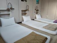 three beds sitting in a room with shelves at Checheng Backpackers Hostel in Checheng