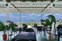 a patio with tables and chairs and a view of the ocean at Resort in青の洞窟 in Ishigaki Island