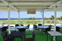 a patio with tables and chairs and the ocean at Resort in青の洞窟 in Ishigaki Island