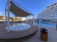 ein Pool mit Sonnenschirm und ein großes Gebäude in der Unterkunft oR-Ya Suite in Eilat