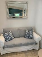 ein Sofa im Wohnzimmer mit Spiegel in der Unterkunft Le Petit Chene in Le Castellet