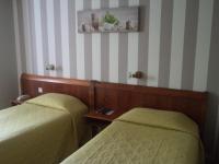 two beds in a room with striped walls at Cit&#39;Hotel Avallon Vauban in Avallon