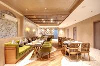 Un restaurante con mesas y sillas en una sala. en IVA Premium Aerocity - Free Airport Pickup or Drop, en Nueva Delhi