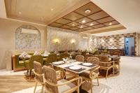 Un restaurante con mesas y sillas en una sala. en IVA Premium Aerocity - Free Airport Pickup or Drop, en Nueva Delhi